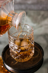 Pouring whiskey in glass with natural ice.