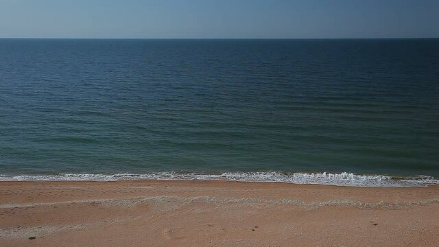 Sea surf, waves on waters, beach with yellow sand on coast.