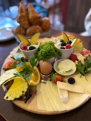 Reichhaltige Frühstücks Platte im Restaurant mit Croissants, Eiern, Obst
