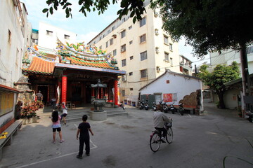 City life in Taiwan with children playing next to a temple