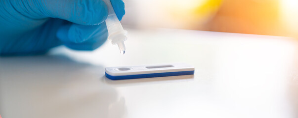 Man using a rapid antigen test kit. Rapid antigen testing is a screening tool to help to detect...