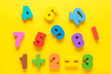 Wooden colored numbers on a yellow background. Mathematic topic. Back to school concept. Child...
