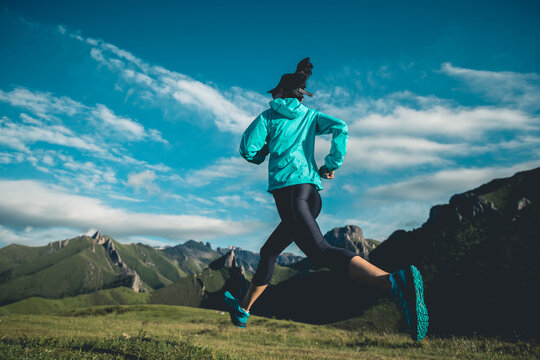 Young woman trail  runner running at mountain top