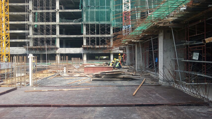 PENANG, MALAYSIA -JUNE 18, 2021: Structural works are underway at the construction site. Construction workers are installing formwork made of metal or timber. Safety features are paramount.
