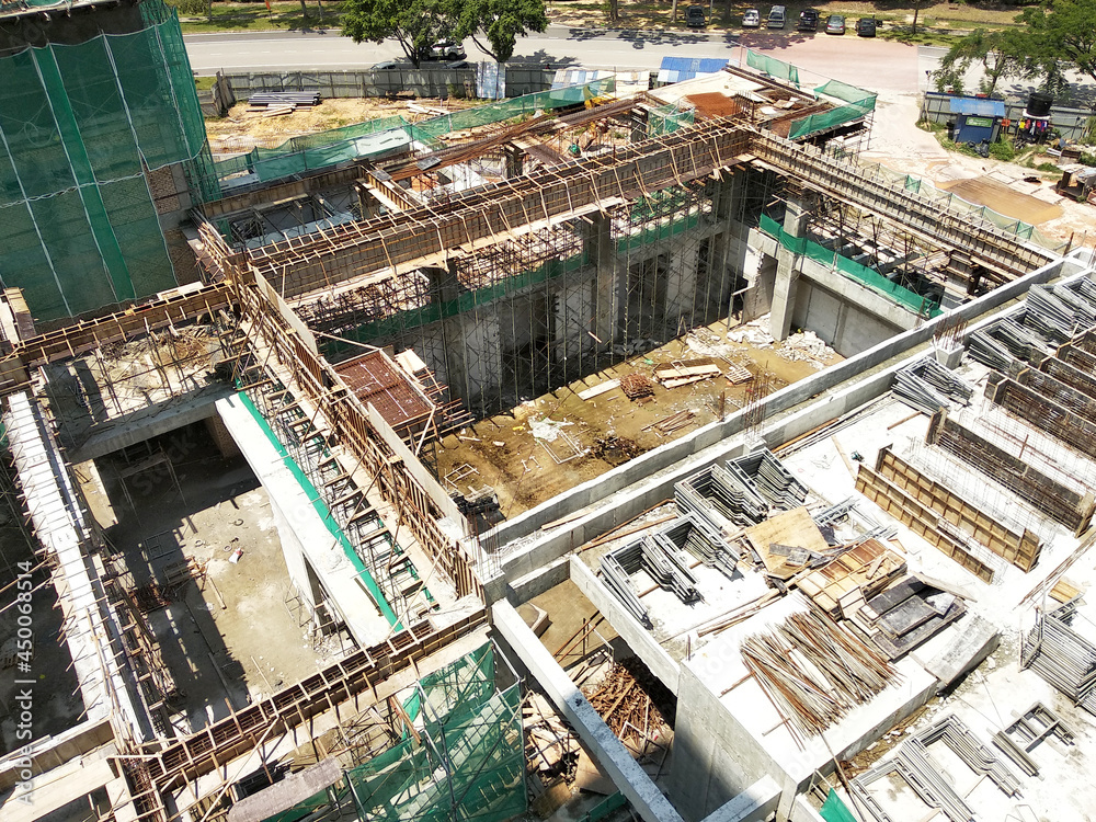 Wall mural PENANG, MALAYSIA -JUNE 18, 2021: Structural works are underway at the construction site. Construction workers are installing formwork made of metal or timber. Safety features are paramount.
