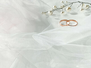 Flat lay background with a pair of gold rings and pearl necklace for wedding or engagement...