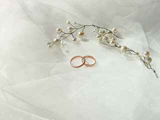 Flat lay background with a pair of gold rings and pearl necklace for wedding or engagement...