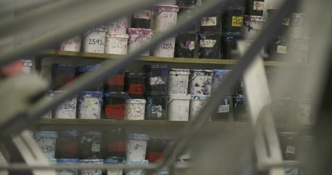 Paint cans on shelf in factory