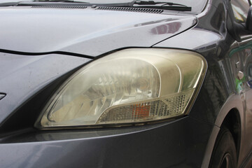 Close-up of yellowed, foggy, eyesore car headlights.