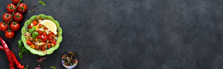 Salad with baked vegetables. Asian salad with eggplant, chili and garlic. On a black concrete background.