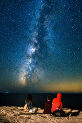 Grupo de personas observando la Vía Láctea sobre el mar Mediterráneo desde la costa de Formentera (Islas Baleares - España)