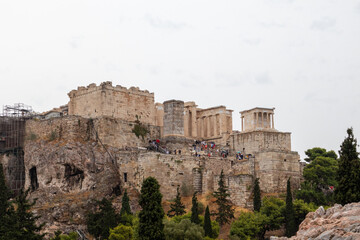 Fototapeta na wymiar Acropolis hill (Parthenon, Temples) in summer cloudy day. Athens ancient historical landmark in city center from Filopappou Hill on cloudy day