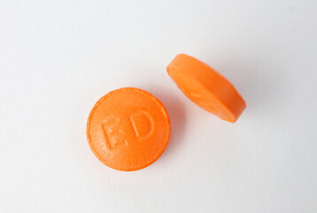 Orange medicine pills on white background. Vitamins.