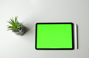 Work place at home with the tablet. Minimalism style top view. Green background