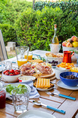 Food on the table.Laid table with food.Breakfast on the terrace.Avocado croutons.Healthy breakfast.Juice is poured for breakfast.The family is eating delicious food.There are many dishes on the table.