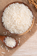 White rice in a bowl on wooden table background.