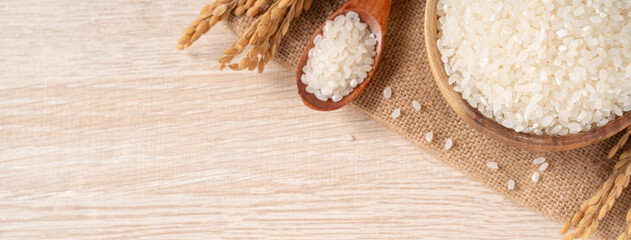 White rice in a bowl on wooden table background.