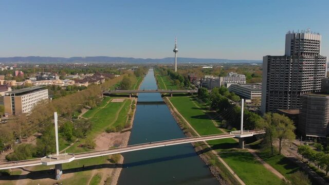 Top view of the embankment of the Neckar River. Bridges, TV tower, green grass and trees. Hospital, tram lines. Mannheim. Germany.