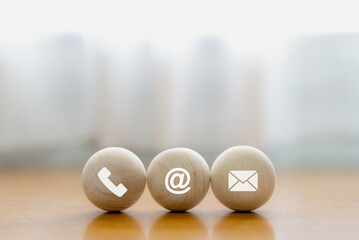 Contact us icon (phone, email, mail ) on wood ball. customer service, help desk and support...