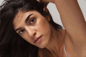 Close-up portrait of young beautiful arabian woman without makeup isolated over gray studio background. Natural beauty concept.