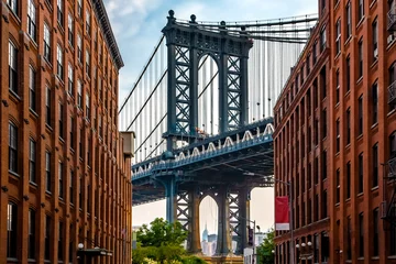 Muurstickers Manhattan Bridge tussen Manhattan en Brooklyn over East River gezien vanuit een smal steegje omsloten door twee bakstenen gebouwen op een zonnige dag in Washington Street in Dumbo, Brooklyn, NYC © Stefan