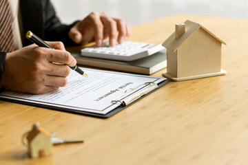 Sales representatives work at the desk with home purchase contracts or on office loans and interest rates.