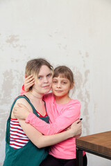 Portrait of two sisters aged 8 and 15 in   bright interior.