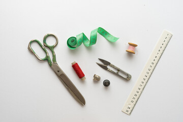 Flat lay composition with scissors and other sewing accessories on light background.