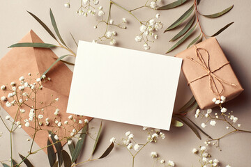 Invitation or greeting card mockup with envelope, gift box and eucalyptus and gypsophila twigs....