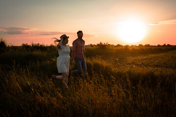 Fototapeta na wymiar Lovely couple walking in the summer field