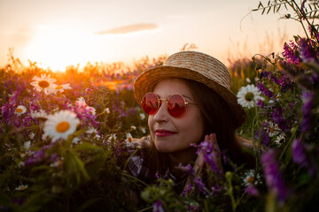 Artistic portrait of woman in red glasses among flowers