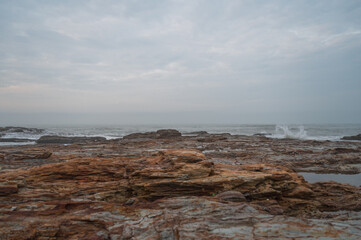 Cloudy seaside, rocks on the beach