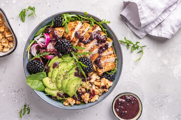 Grilled chicken breast, fillet and fresh vegetable salad of lettuce, arugula, spinach, avocado, onion and walnut with blackberry dressing. Healthy lunch menu. Diet food. Top view