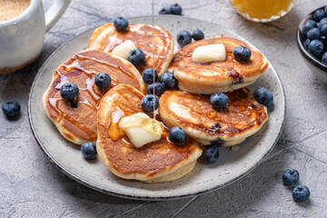 Buttermilk blueberry pancakes with maple syrup and fresh blueberries