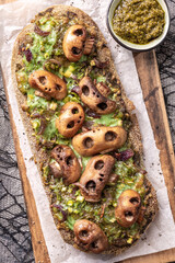 Halloween spooky pizza bread with skull-shaped mushrooms. Halloween lunch food