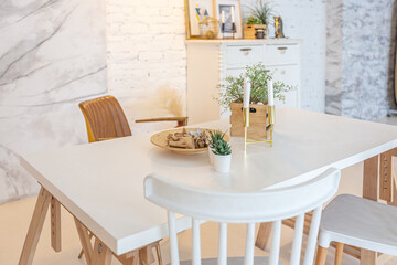 Fototapeta na wymiar Fashionable modern interior of a light studio apartment with wooden columns in the loft style, decorated with brick, marble and wood with stylish furniture and white walls