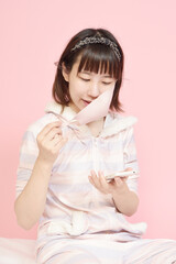 マスクを外しながらスマホを見る女性