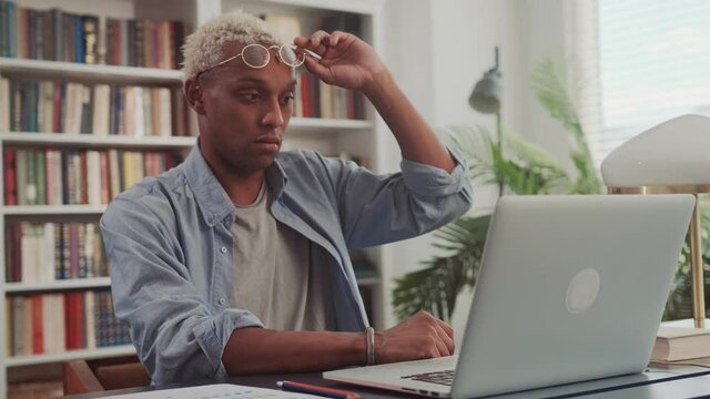 Frustrated upset dark skinned business man stressed about computer problem, bad online news financial market crisis, sad desperate african ceo feel loser sit at desk with laptop shocked by bankruptcy.