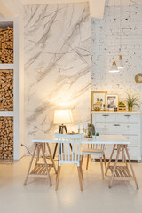 Fashionable modern interior of a light studio apartment with wooden columns in the loft style, decorated with brick, marble and wood with stylish furniture and white walls