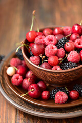 Close-up colorful berries. Assorted mix of raspberry, blackberry, gooseberry and sweet cherry. Selective focus
