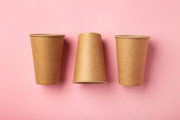 Disposable paper cups on pink background. Coffee concept.