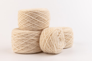 balls of light woolen thread on white background. natural wool. knitting. background