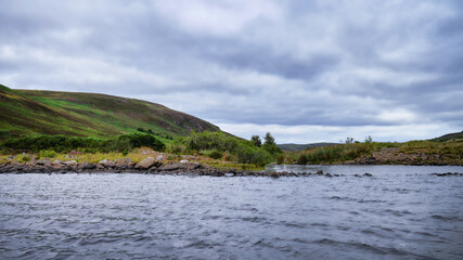 Loch Buidhe in Strath Carnaig in Sutherland in the Highlands with the Abhainn An t-Sratha Charnaig river running out of the tail end of the loch