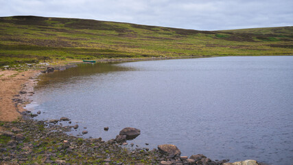 Loch Buidhe in Strath Carnaig in Sutherland in the Highlands with a canoe on the shore