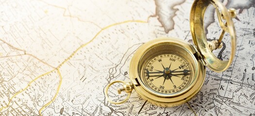 Retro styled golden compass (sundial) and old white nautical chart close-up. Vintage still life. Sailing accessories. Travel and navigation theme