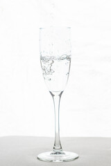 Filling up the champagne glass water  isolated on a white background