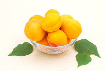 Ripe juicy summer apricots in a transparent plate close-up.