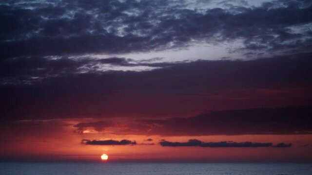 Seascape at early morning. Time lapse of dark stormy clouds moving over sea at sunrise. Nature landscape in Spain.