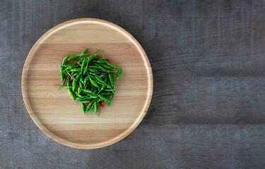 Red and Green hot chilli in a wooden tray on wooden floor