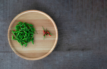 Red and Green hot chilli in a wooden tray on wooden floor